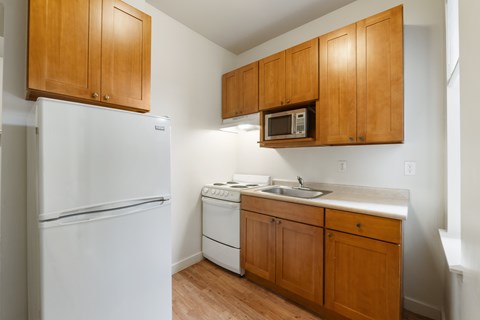 A kitchen with white appliances and wooden cabinets.