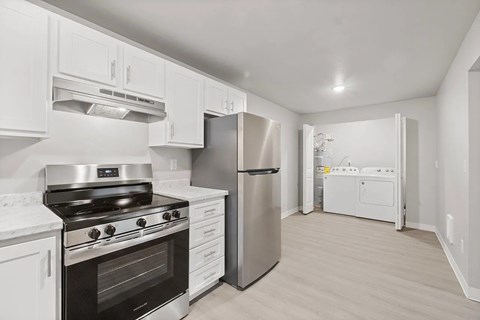 A kitchen with white cabinets and stainless steel appliances.