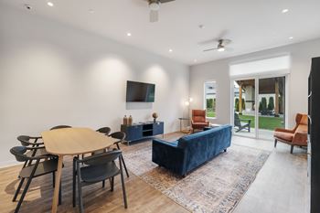 A living room with a blue couch and a wooden table.