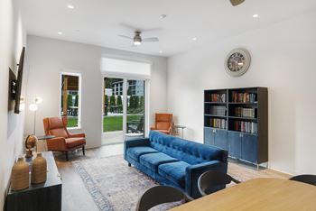 A living room with a blue couch and a ceiling fan.