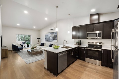 A modern kitchen with dark wood cabinets and stainless steel appliances.