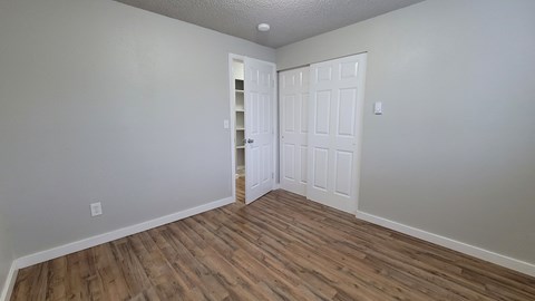 A room with two white doors and wood flooring.