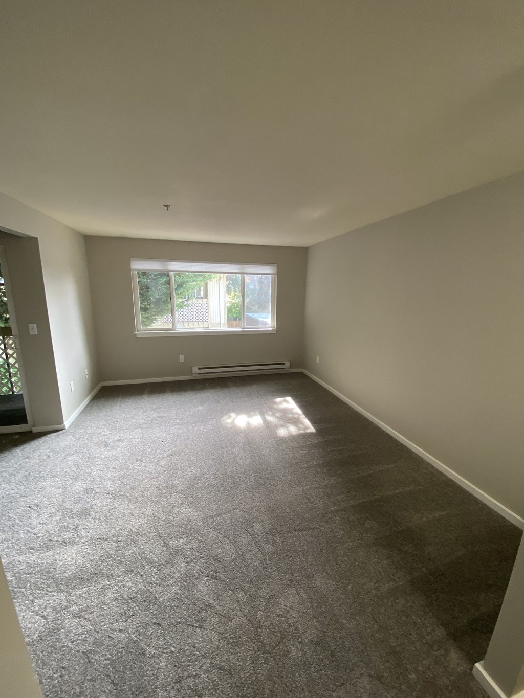 an empty room with carpet and a window