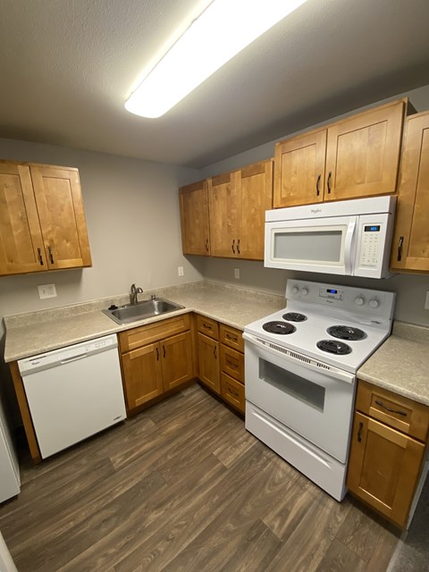 a kitchen with white appliances and wooden cabinets