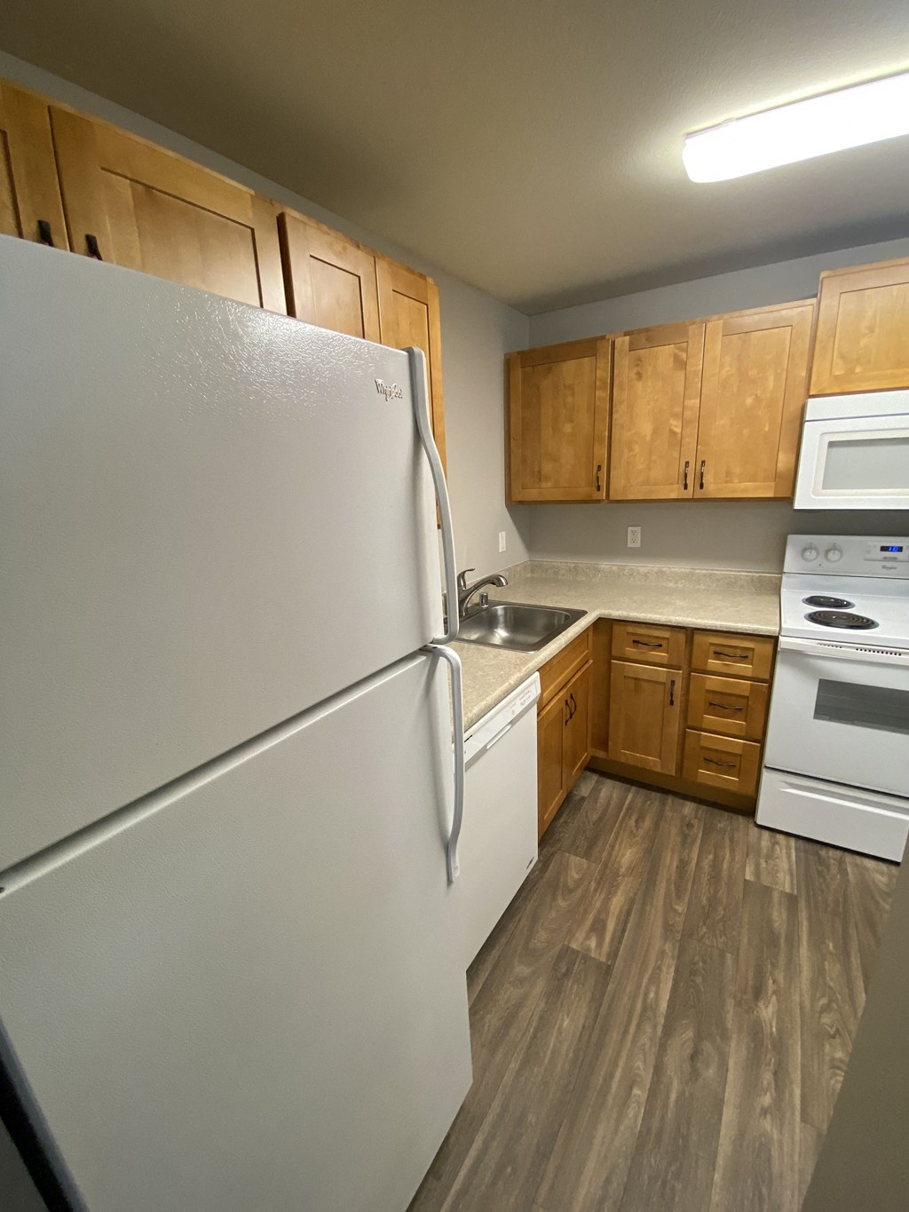 a kitchen with white appliances and wooden cabinets