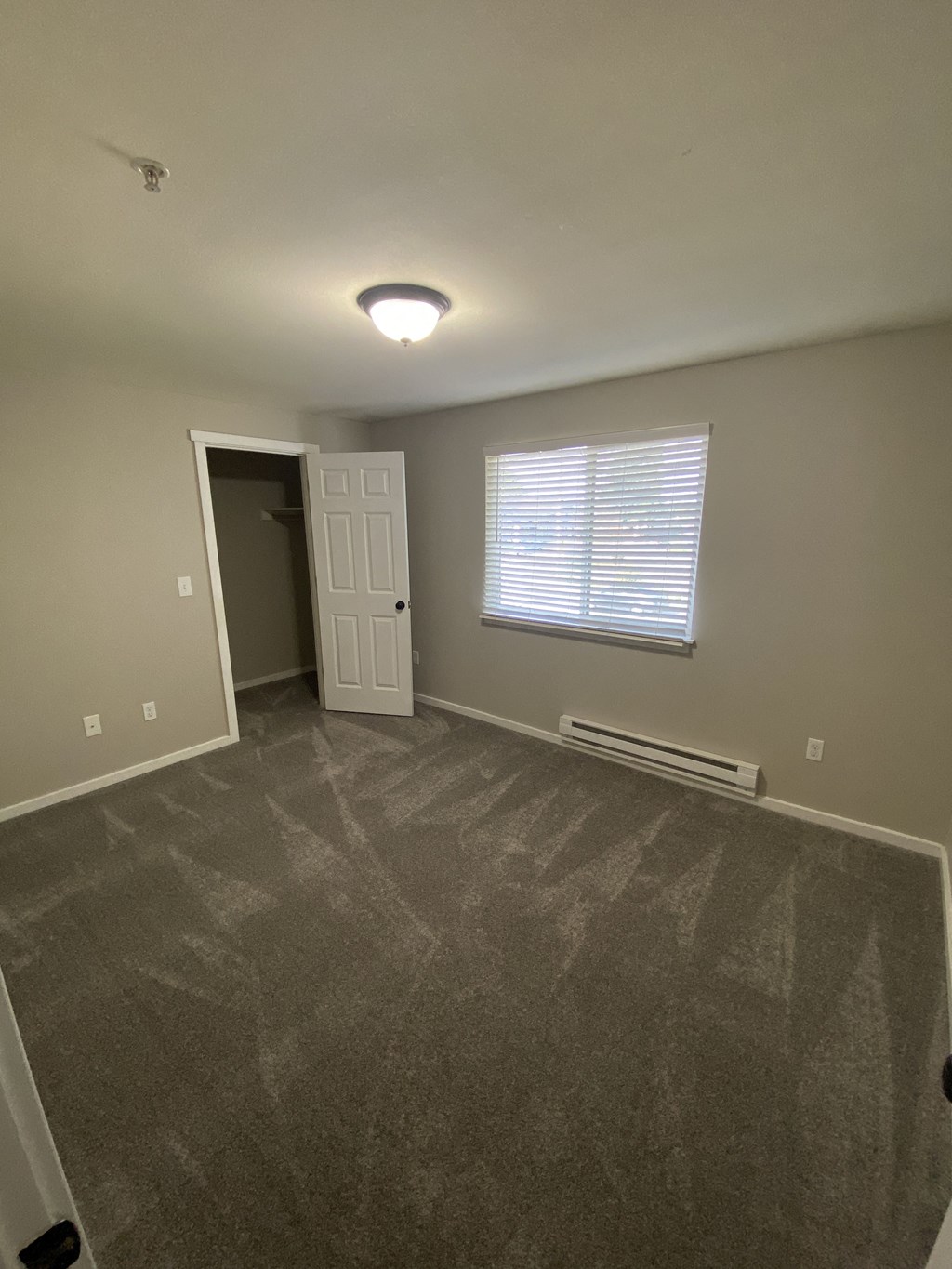 an empty living room with a door and a window