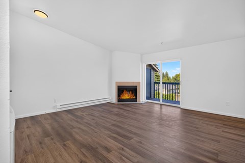A room with a fireplace and a view of the outdoors through a sliding glass door.