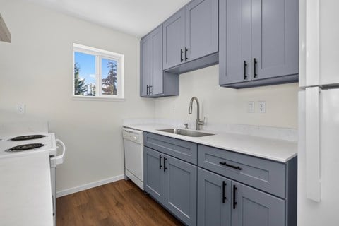 A kitchen with a white stove and a white refrigerator.