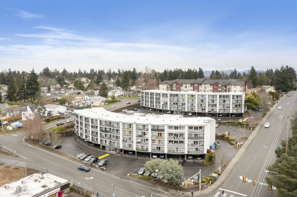an aerial view of a large white building next to a street