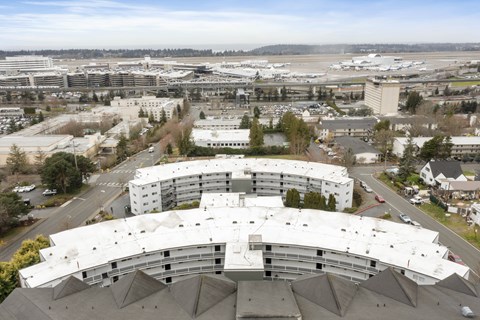 an aerial view of a building with an airport in the background