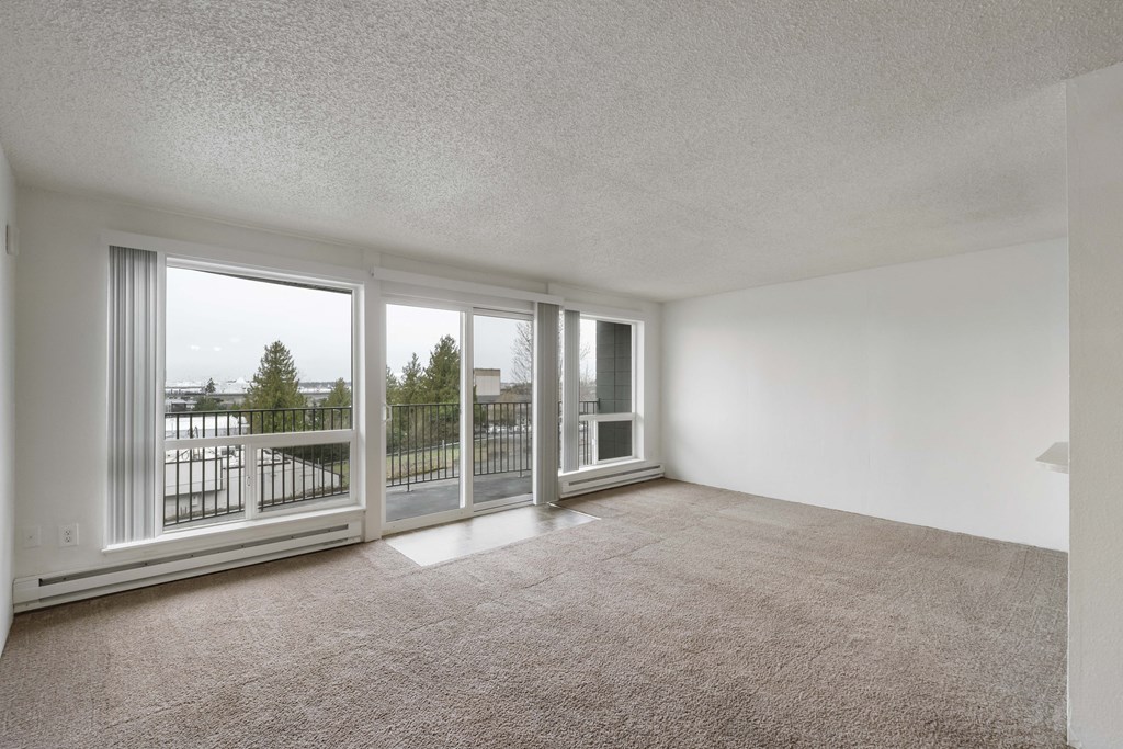an empty living room with sliding glass doors to a balcony