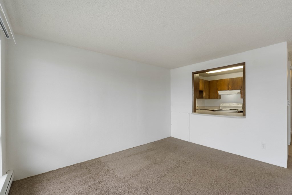 an empty living room with white walls and a window