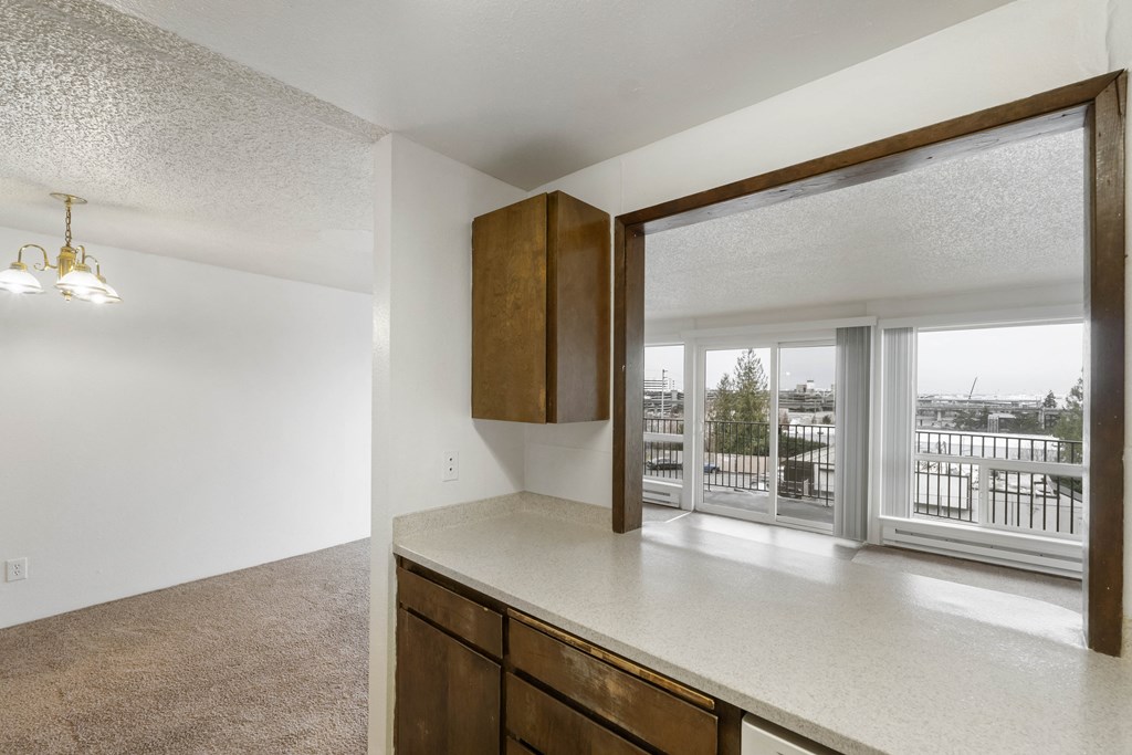 a kitchen with an island and a window with a view of a balcony