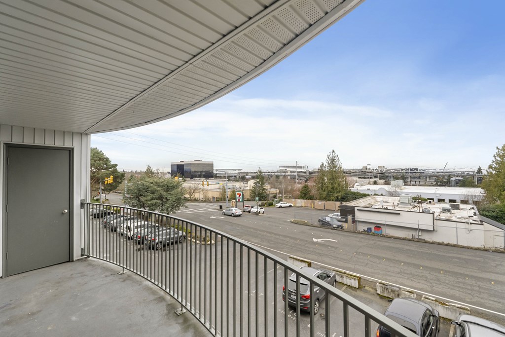 the view of a parking lot from a balcony of a building