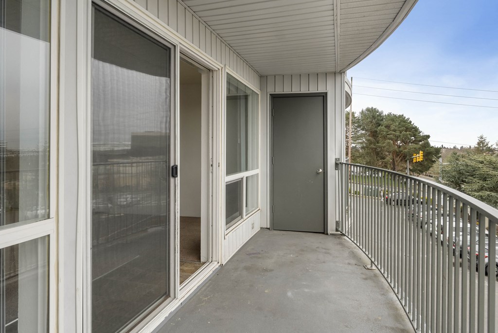 the view from the balcony of a home with a large screen door to the patio