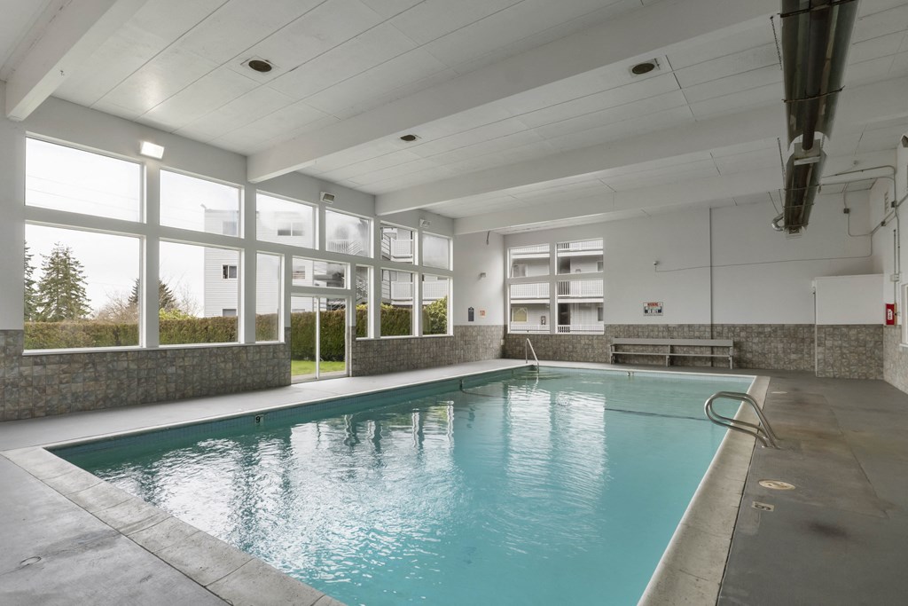 a swimming pool in a building with large windows