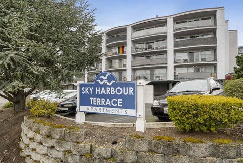 an apartment building with a sign for sky harbour terrace apartments