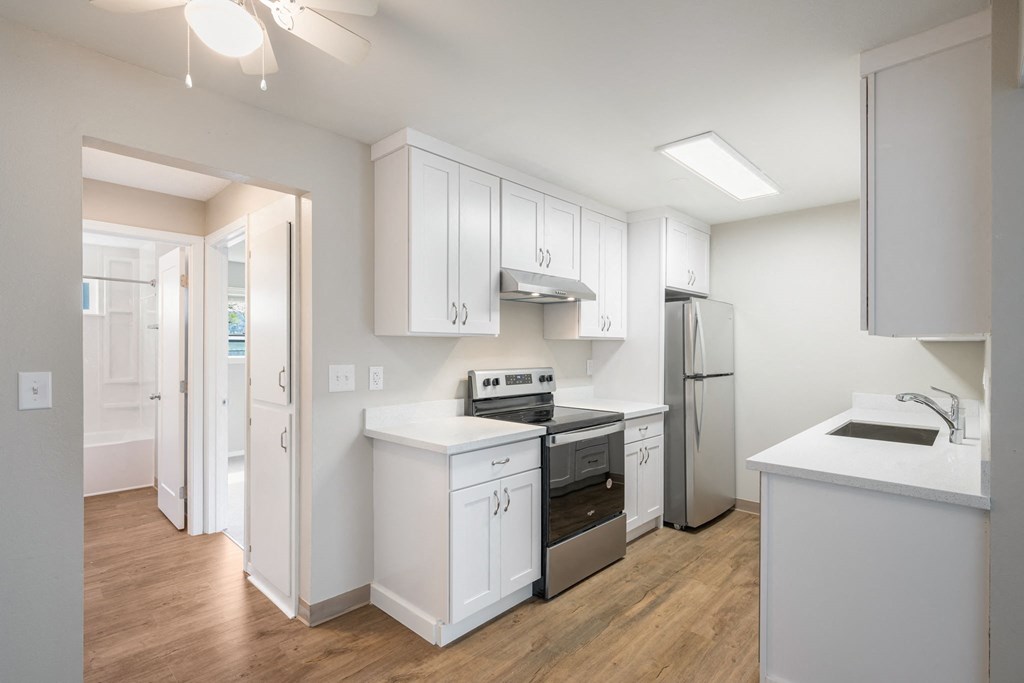 A kitchen with white cabinets and appliances.