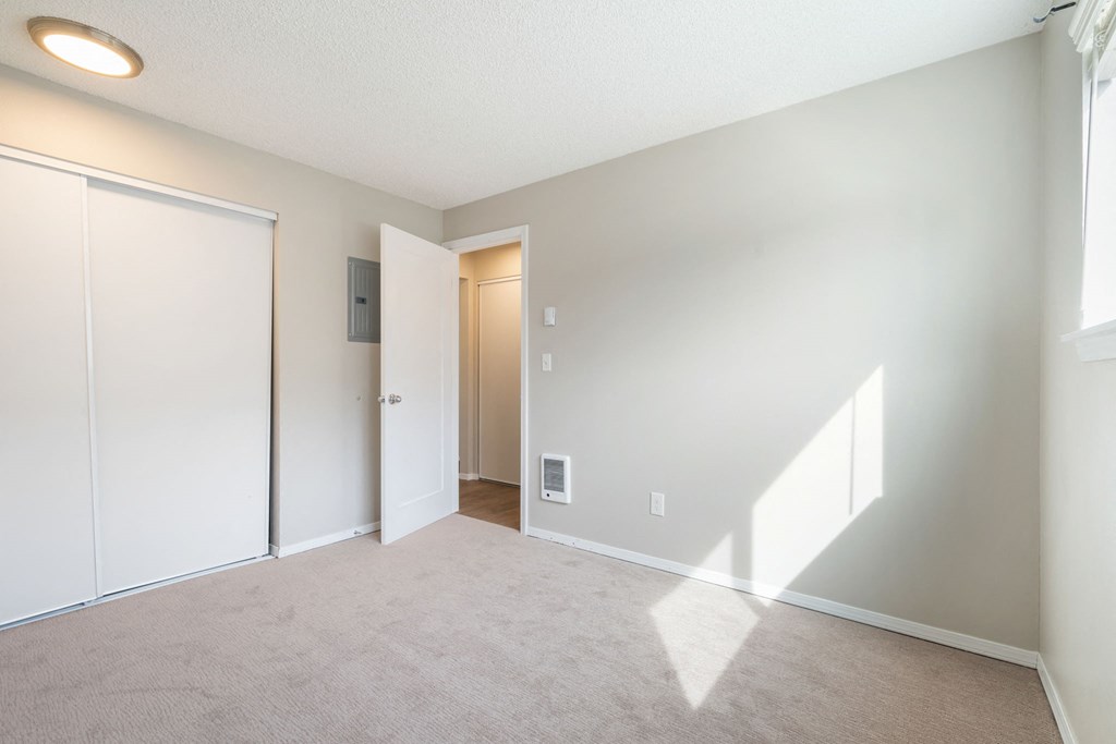 A room with a carpeted floor and a white door.