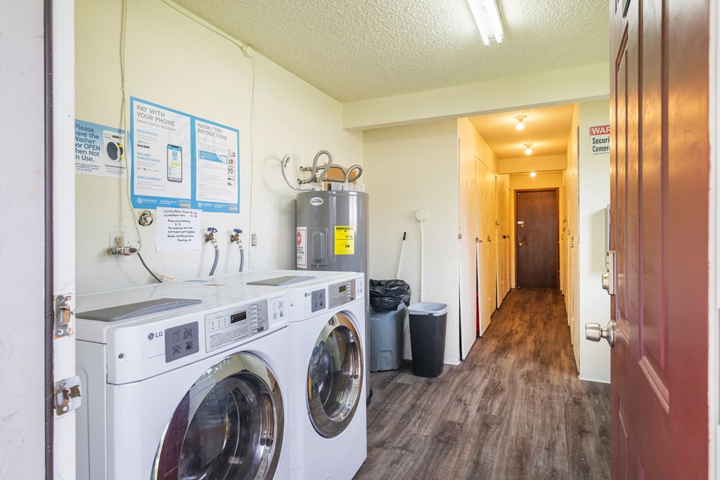 A laundry room with washers and dryers and a sign on the wall.