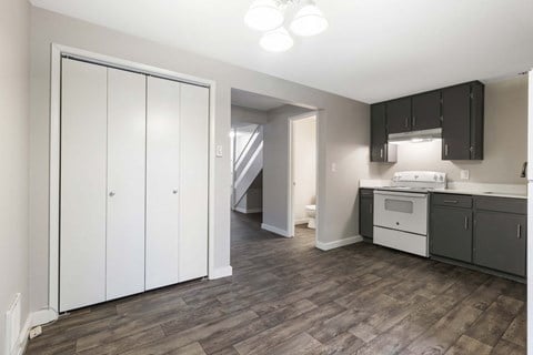 a white and black kitchen with dark cabinets and white appliances