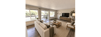 A living room with a couch, a coffee table, and a television.