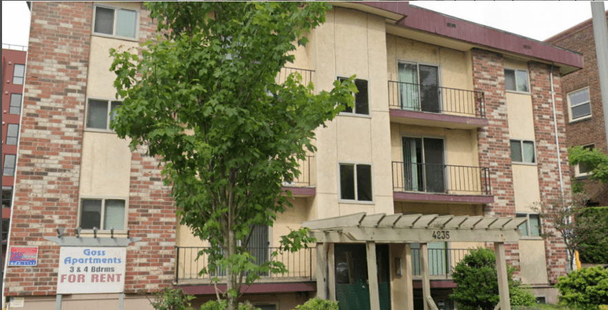 Apartment building with a sign that says "Goss Apartments for Rent".
