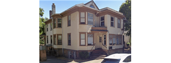 A two story house with a white car parked in front.