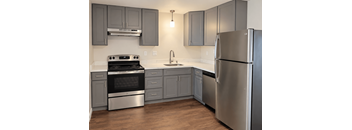 A modern kitchen with a stainless steel refrigerator and oven.