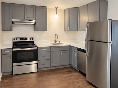 A modern kitchen with a stainless steel refrigerator and oven.