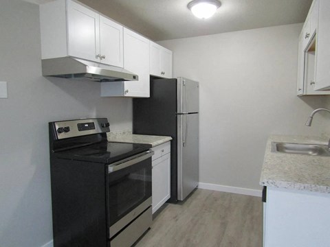 A kitchen with black appliances and white cabinets.