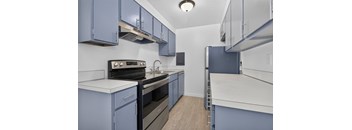 A kitchen with blue cabinets and white countertops.