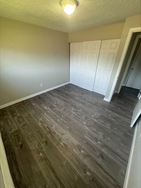 A room with wood flooring and white walls.
