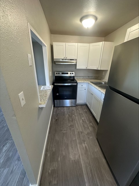 A kitchen with a stove top oven and a refrigerator.