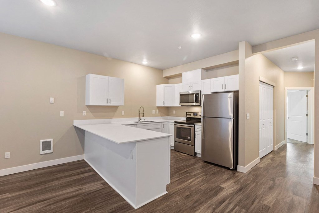 a kitchen with white cabinets and a stainless steel refrigerator