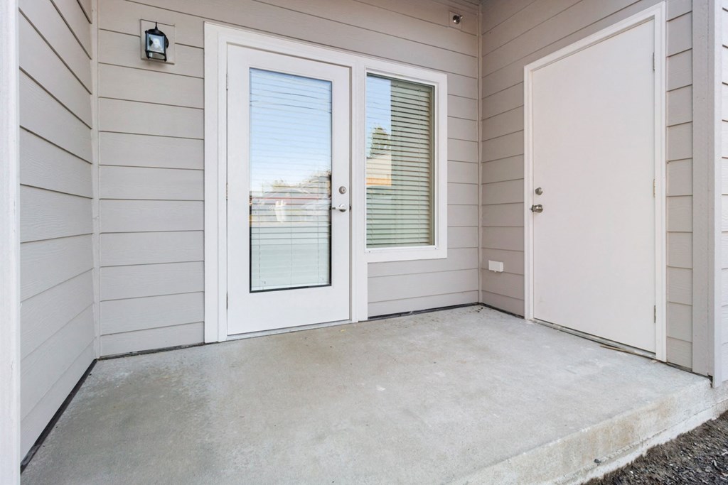 the front porch of a home with a white door