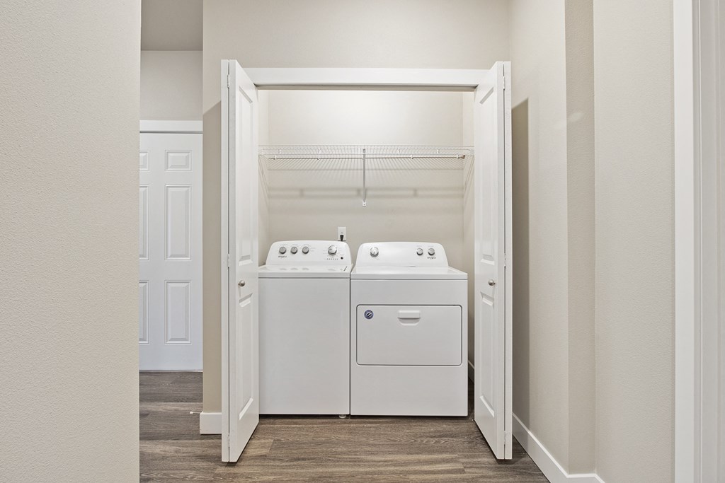 a laundry room with a washer and dryer and a closet with a door