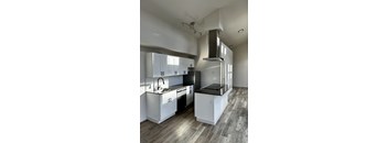 A modern kitchen with a stainless steel sink and black appliances.