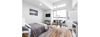 A bedroom with a bed, a table, and a television.