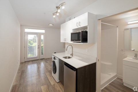 A modern kitchen with a washer and dryer built in.