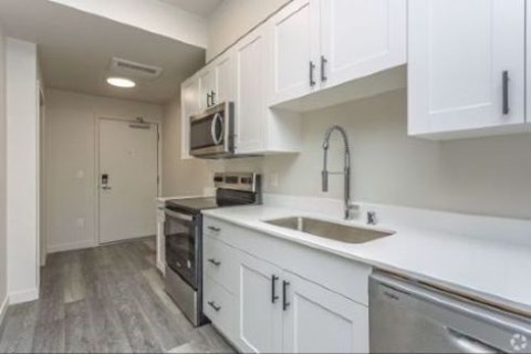 A kitchen with white cabinets and stainless steel appliances.