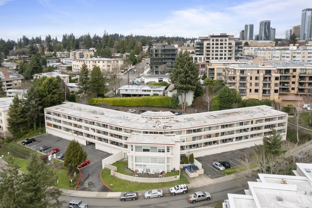 an aerial view of a large white building with a parking lot
