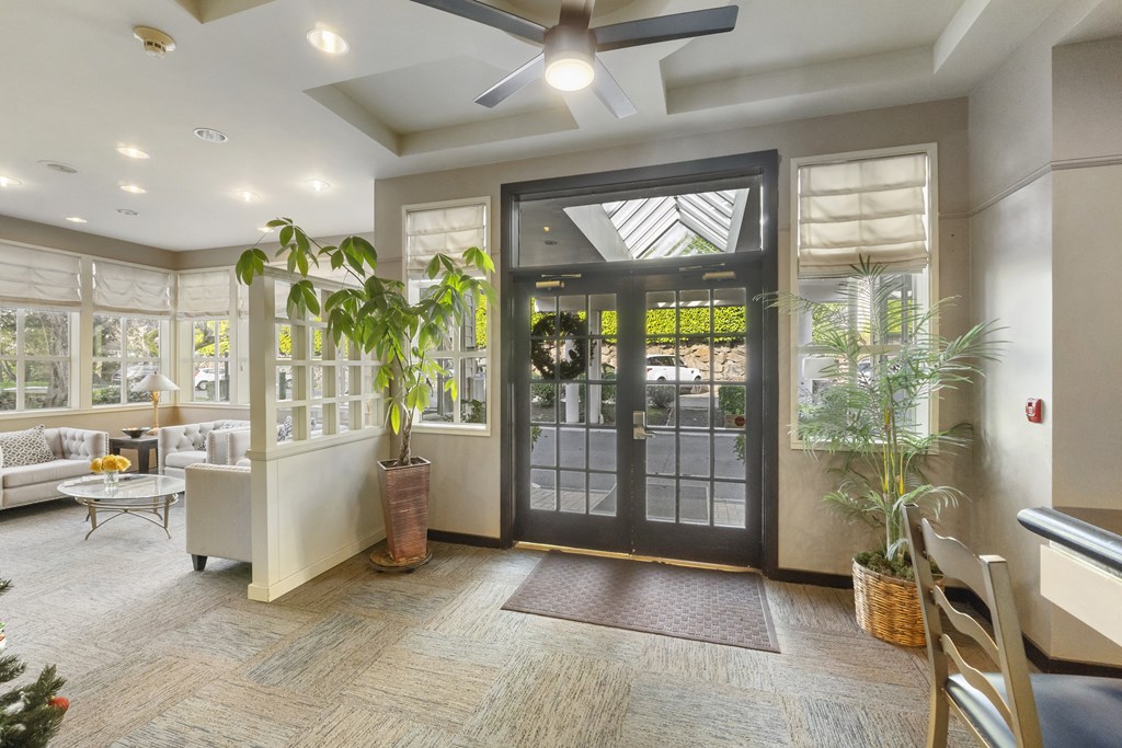 the lobby of a home with a glass door and a ceiling fan