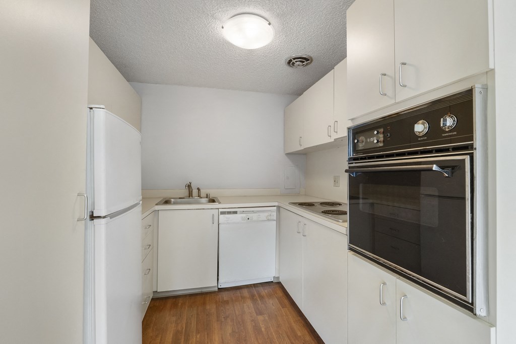 an empty kitchen with white cabinets and a black stove and refrigerator