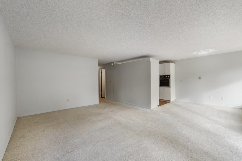 the living room and kitchen of an empty apartment with white walls and flooring