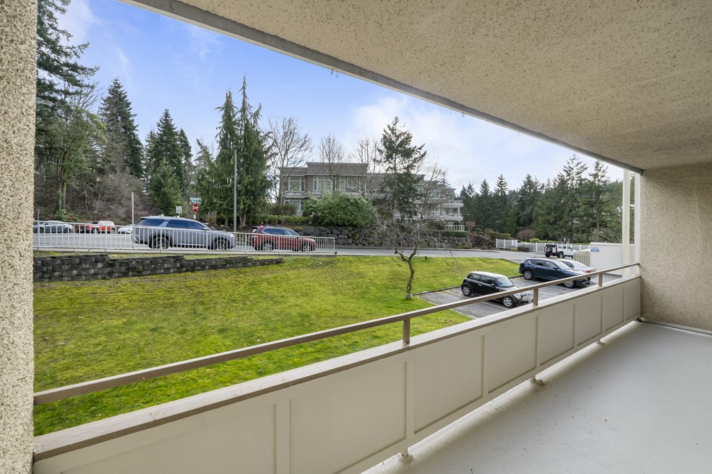 the view of a parking lot from a balcony of a building