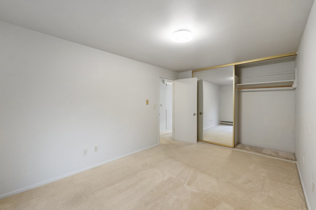a living room with white walls and a door to a closet