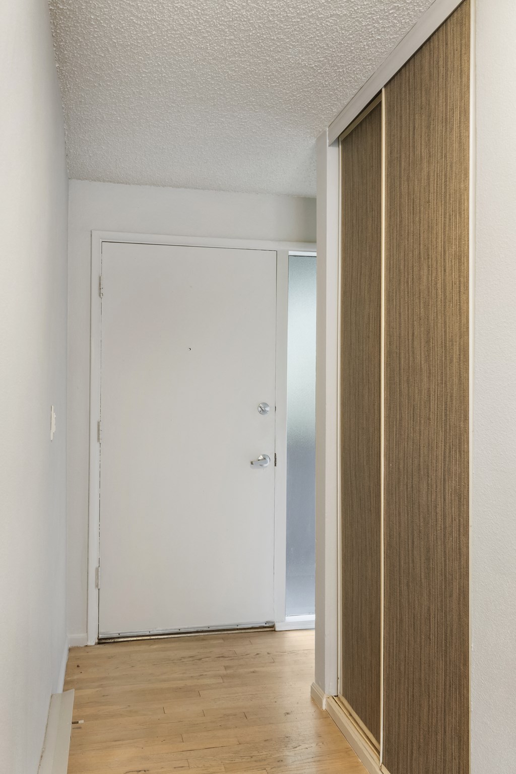 an empty room with a wooden floor and a white door