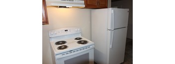 A white stove and refrigerator in a kitchen.