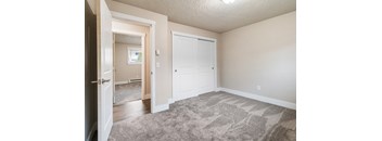 an empty living room with a door to a bedroom